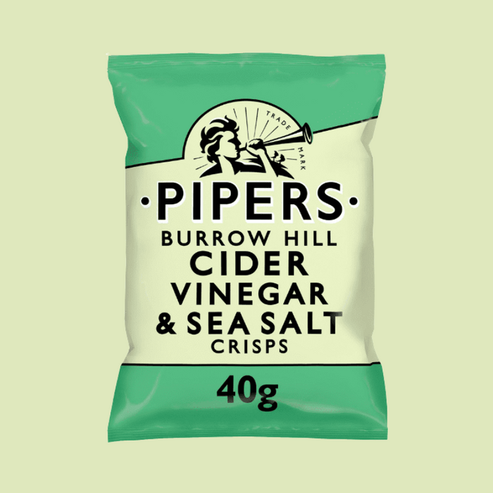 A close-up of golden crisps with a bottle of cider vinegar in the background.