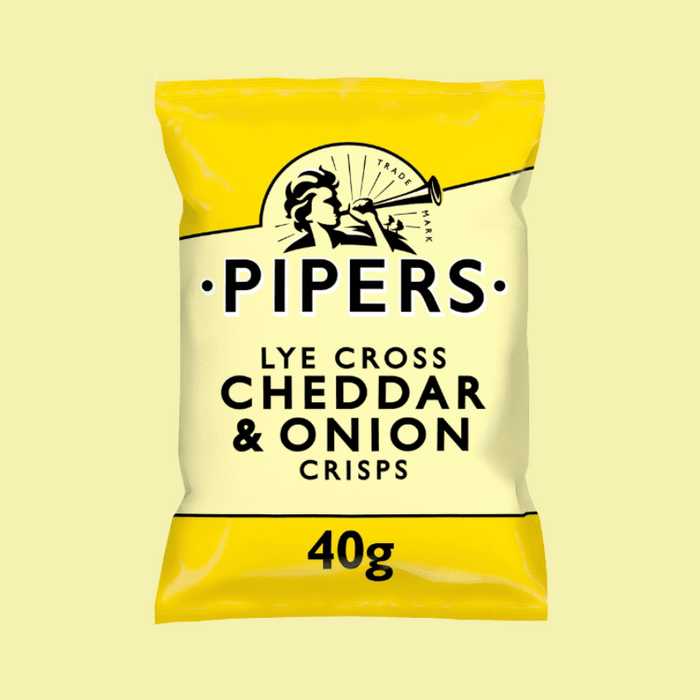 A close-up of crisps with a wedge of mature Cheddar and onions in the background.