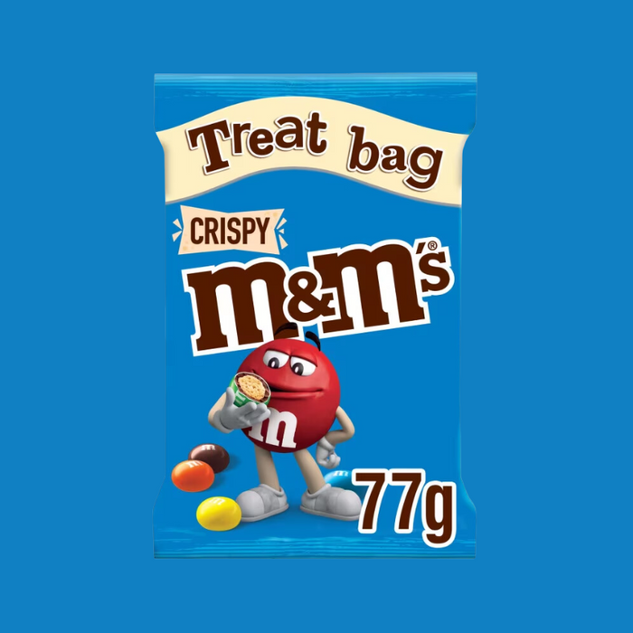 A bowl of M&M's Crispy poured out of a treat bag, highlighting the crispy rice centers.