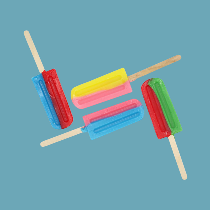 A hand holding a lollipop, highlighting its glossy hard candy texture.