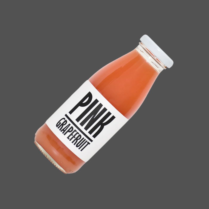 A glass of freshly poured pink grapefruit juice with natural cloudiness.