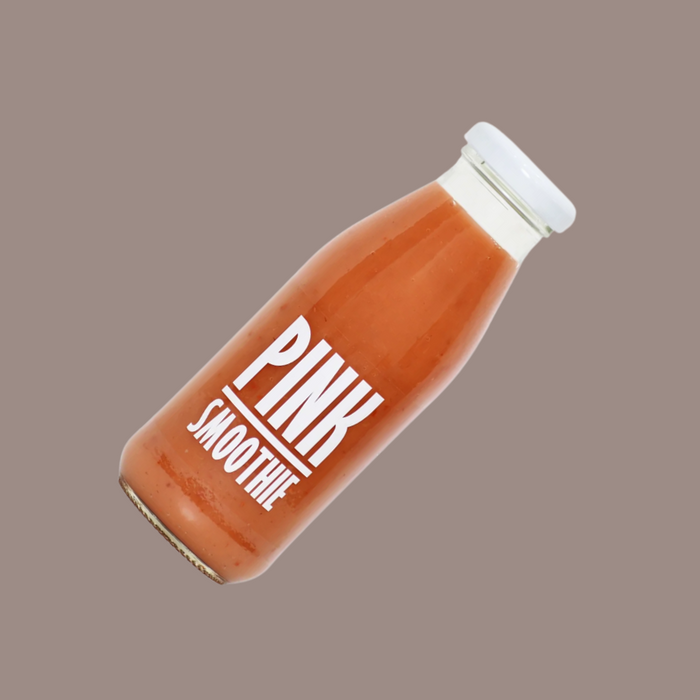 A glass of the pink smoothie served chilled with a fruit garnish.