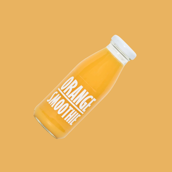 Pressuice Orange Smoothie being poured into a clear glass with visible fruit fibres