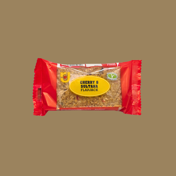 Row of 24 individually wrapped Cherry & Sultana flapjacks on a wooden board

