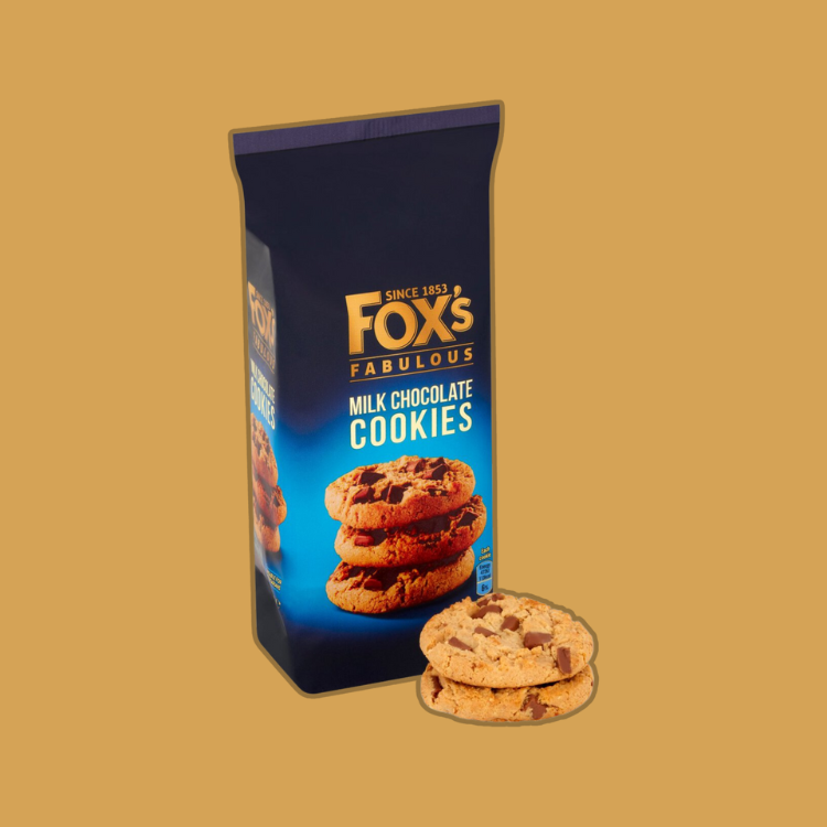 Fox's Milk Chocolate Cookies served on a plate with a cup of coffee in the background.
