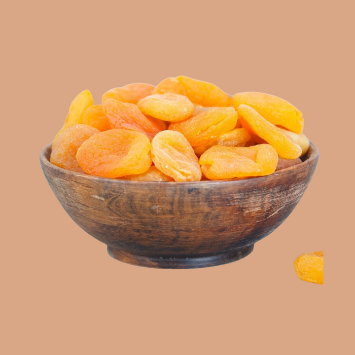 Wooden bowl filled with dried apricots on a beige background