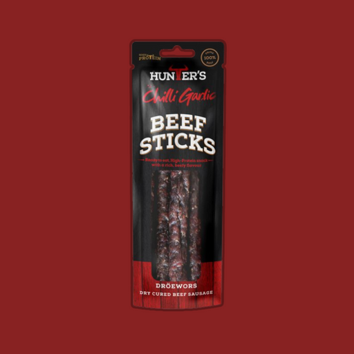 A person enjoying Hunters Chilli Garlic Beef Sticks during an outdoor adventure.