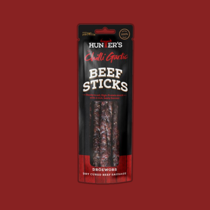 A person enjoying Hunters Chilli Garlic Beef Sticks during an outdoor adventure.