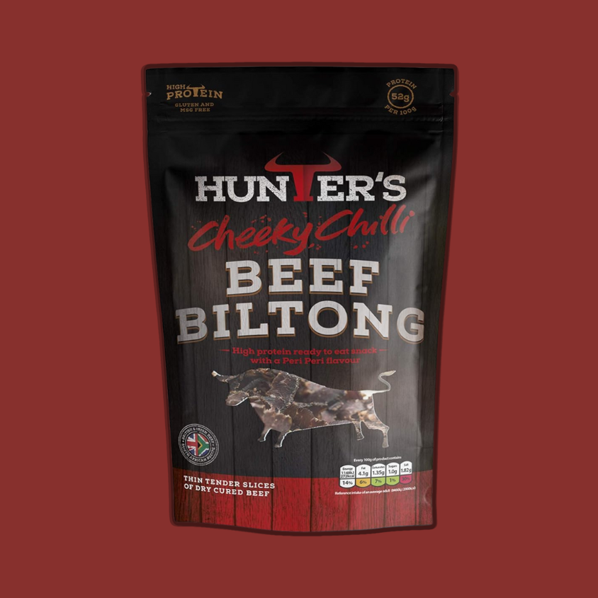 Hunters Chilli Beef Sliced Biltong pack lying on a rustic kitchen table.