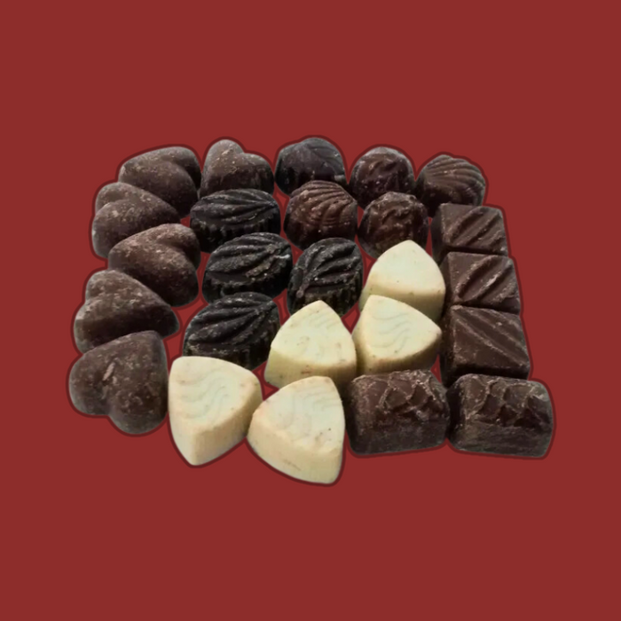 A hand holding a piece of Walkers Misshaped Chocolate, highlighting the texture and fillings.