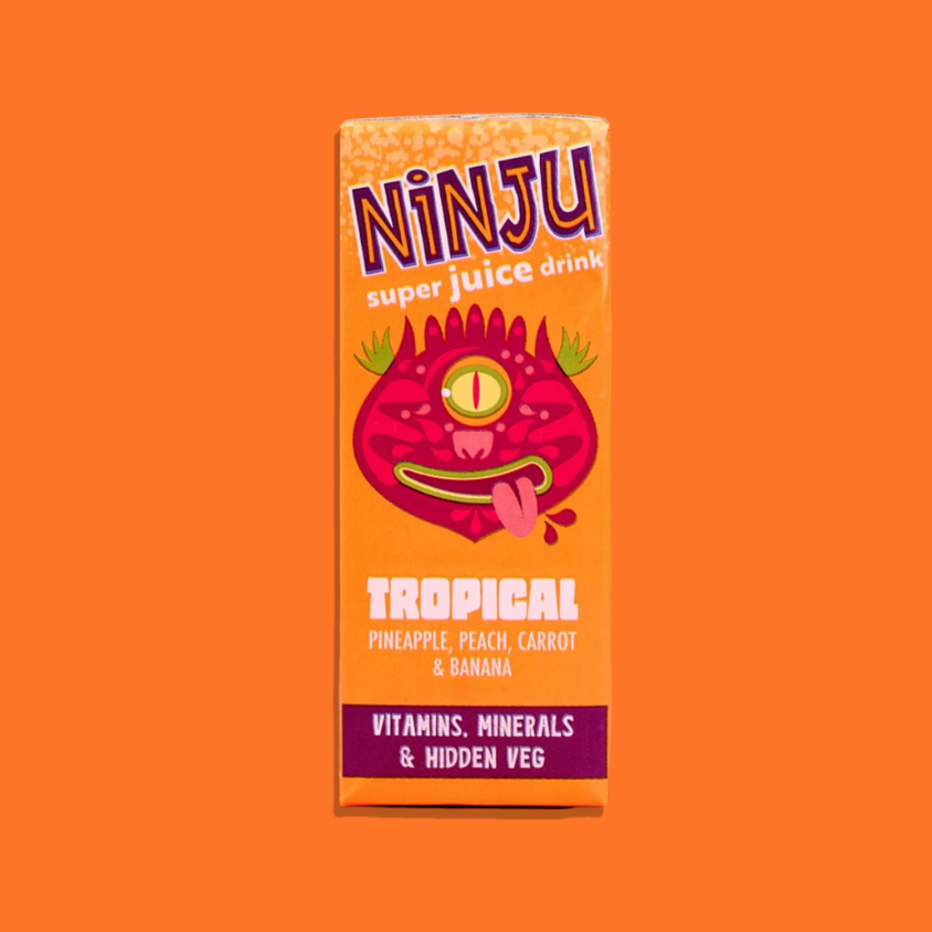 Ninju Tropical Super Juice poured into a glass with tropical fruits