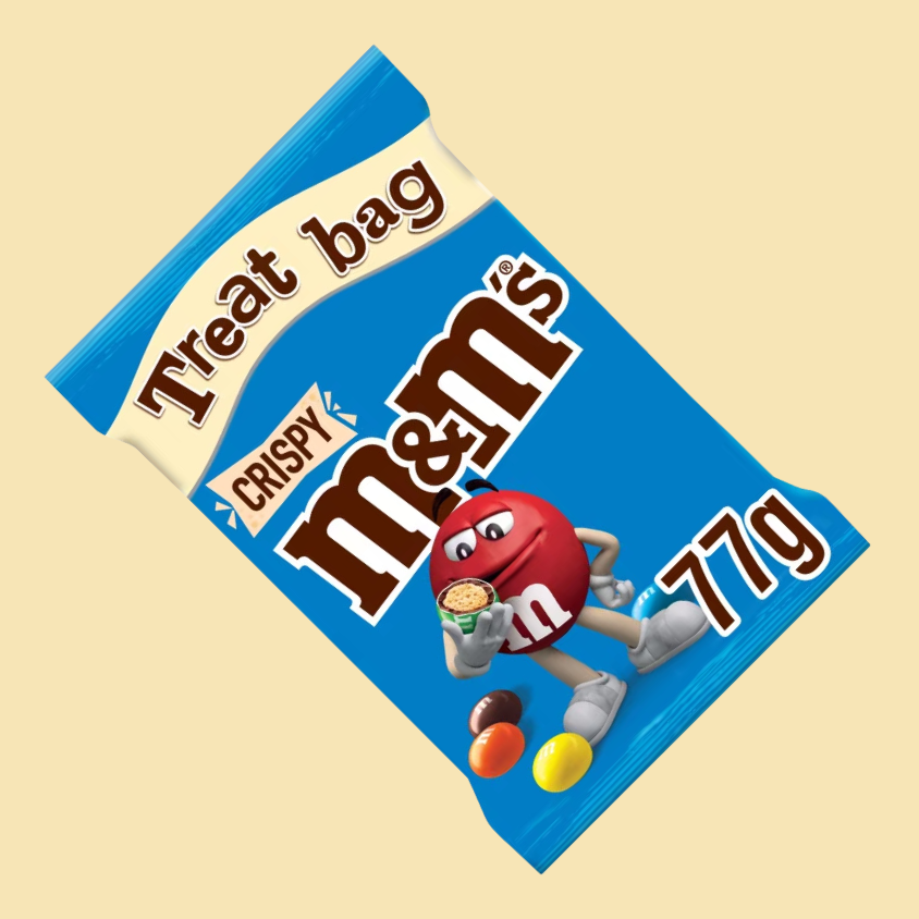 A single M&M Crispy broken open to reveal its crispy rice core and chocolate layer.