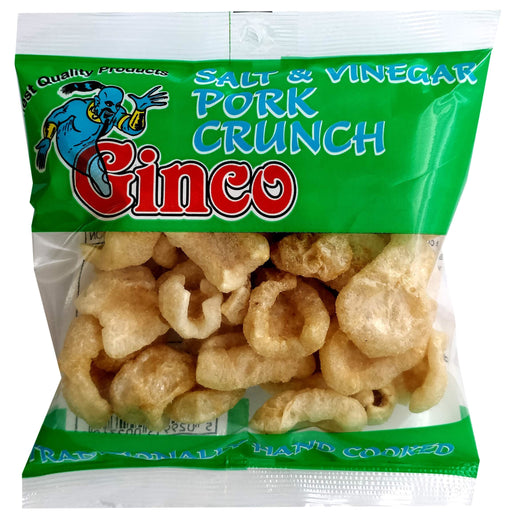 Close-up of crispy Ginco Salt & Vinegar Pork Crunch pieces beside stacked snack bags, showing tangy seasoning and crunchy texture from a 12-pack